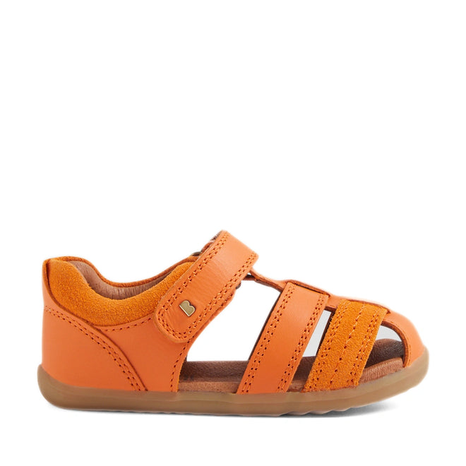 The Bobux Step Up Sandal Roam Closed Toe Sandals in Orange Peel feature bright orange leather with an open toe, closed heel, and three side straps. Designed with a Velcro closure on top and a brown flexible sole, these sandals are shown against a white background., 9420074807250, 9420074807267, 9420074807274