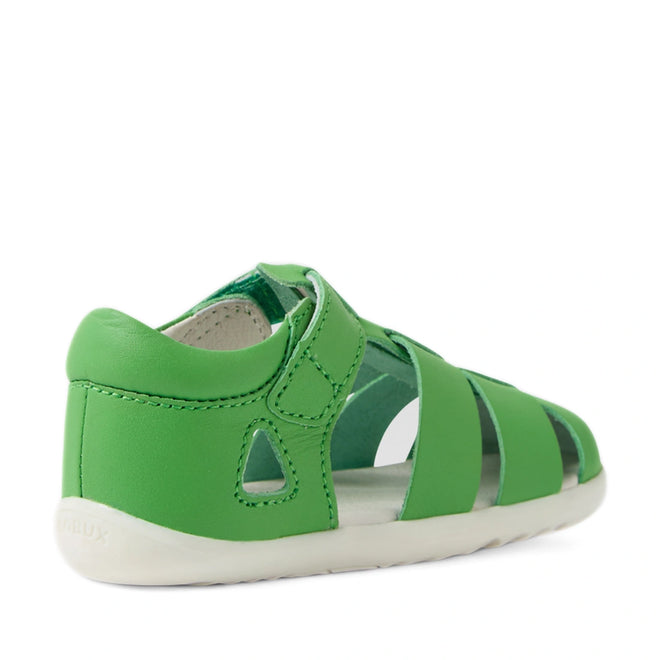 A green, closed-toe toddler sandal with a white sole and a Velcro strap, viewed from the back left side—the Bobux Step Up SU Toddlers Tidal Retro Green Closed Toe Sandal is designed for little adventurers taking their first steps in style., 9420074808424, 9420074808431, 9420074808448, 9420074808455