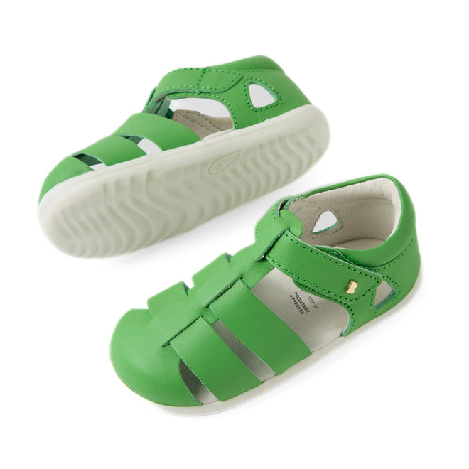 Two Bobux Step Up SU Toddlers Tidal Retro Green Closed Toe Sandals are pictured from the side and top. These water-friendly leather sandals, featuring cut-out details and a small gold button on the side, have white rubber soles. Designed for everyday adventures, they’re ideal closed-toe sandals for toddlers., 9420074808424, 9420074808431, 9420074808448, 9420074808455