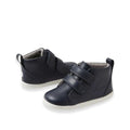 A pair of Bobux Step Up Grass Court Hi Boot Navy toddler sneakers with white soles, two Velcro straps, and a pull tab at the heel, displayed on a white background.