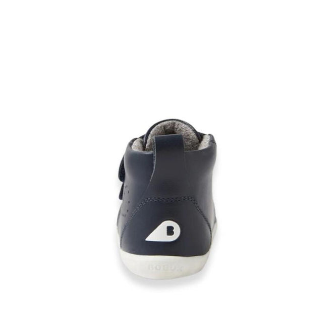 Rear view of a single Bobux Step Up Grass Court Hi Boot Navy toddler sneaker with a white sole and stylized "B" logo on the heel, photographed against a plain white background., 9420075771741, 9420075774490, 9420075778368