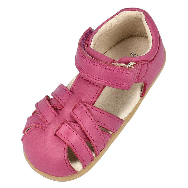 The Bobux Step Ups Cross Jump Mauve Haze 731116 is a pink closed-toe first walker sandal for kids, featuring woven leather upper straps, an ankle hook-and-loop closure, and a soft beige lining and sole., 9420075773622, 9420075773288, 9420075769649, 9420075768871