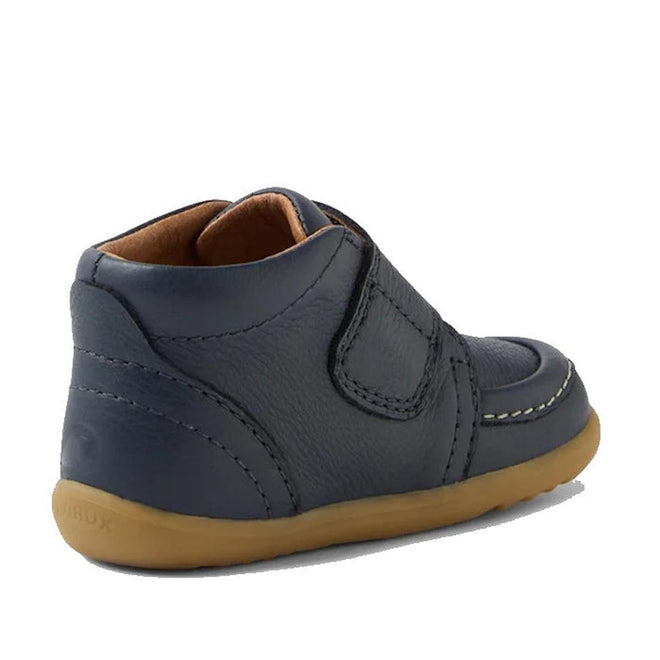 The Bobux Step Up First Walkers Grover Leather Boot in navy is shown from a rear side angle, featuring a tan rubber sole, visible stitching, and a Velcro strap—ideal first shoes for babies—on a white background., 9420074831750, 9420074831767, 9420074831774, 9420074831781
