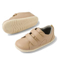 The Bobux Step Up Grass Court Trainer Warm Taupe Shoes are light beige leather toddler sneakers with white soles, Velcro straps, and small ventilation perforations—ideal first walker shoes for little ones., 9420074802033, 9420074802040, 9420074802057