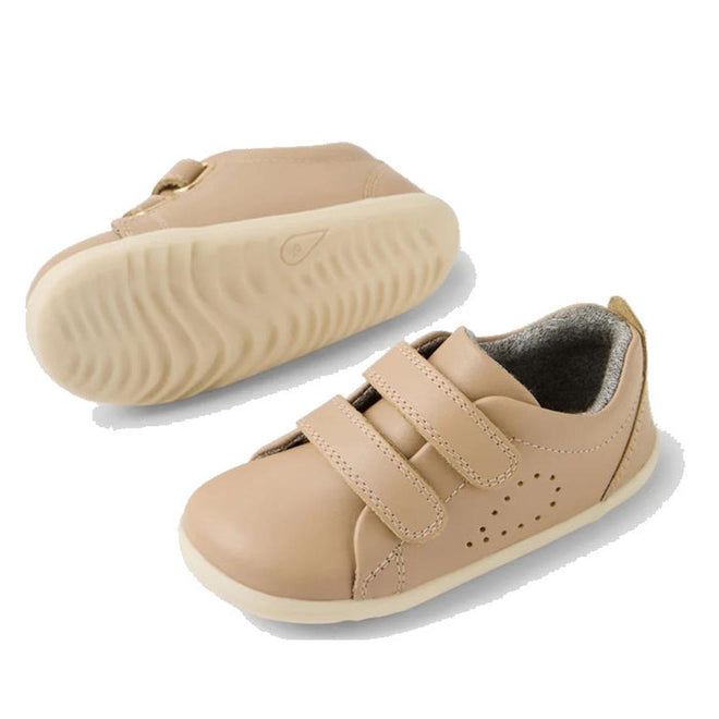 The Bobux Step Up Grass Court Trainer Warm Taupe Shoes are light beige leather toddler sneakers with white soles, Velcro straps, and small ventilation perforations—ideal first walker shoes for little ones., 9420074802033, 9420074802040, 9420074802057