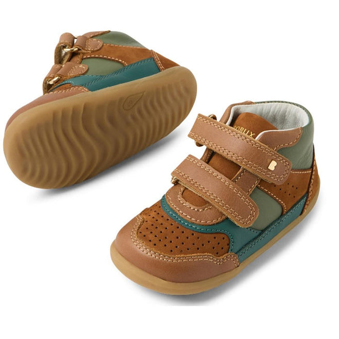 The Bobux SU Harley First Walker Leather Boots Tan are toddler boots with brown, tan, green, and teal leather panels, velcro straps, and rubber soles. One boot stands upright while the other displays its textured sole., 9420074833266, 9420074833273, 9420074833280, 9420074833297