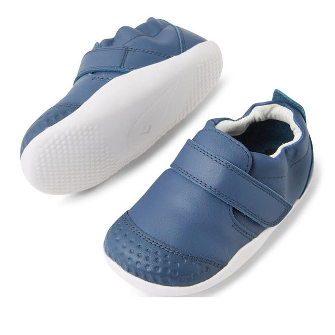 The Bobux XP Xplorer First Walking Shoes Go Vintage Indigo Blue are toddler pre-walker leather shoes with flexible soles, white edges, a single velcro strap, and textured toes, shown from the side and top on a white background., 9420074842657, 9420074842664, 9420074842671, 9420074842688