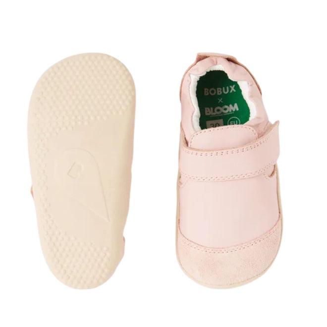 A pair of Bobux Explorer Marvel Ballet Pink Dress Shoe First Walkers, featuring light pink leather uppers, white textured soles, and a green insole with BOBUX x BLOOM text—perfect pre walker shoes for little feet.