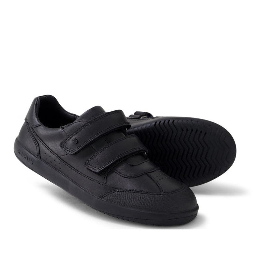 The Bobux Kid+ Black School Leather Shoe Traverse Trainer features two adjustable straps—one upright, one sideways—and a durable tread pattern, making it the perfect sneaker-style school shoe for kids.