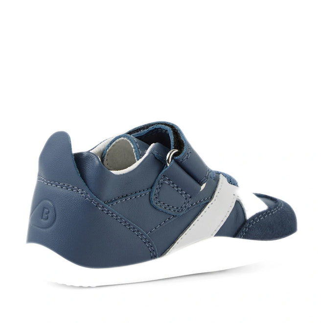 The Bobux Xplorer XP Chase Vintage Indigo Blue First Walker Crawler, a navy blue and white toddler sneaker with a velcro strap, is shown from a rear side angle on a white background., 9420074850638, 9420074850645, 9420074850652, 9420074850669