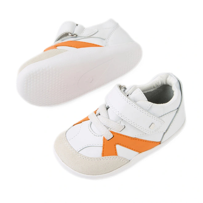 A pair of Bobux Xplorer XP Chase White Orange Peel First Walker Crawler shoes featuring a white design with orange accents, beige toe caps, white soles, and Velcro straps. These pre-walker sneakers have a flexible sole for added comfort and are shown with one shoe from the side and the other from the bottom., 9420074850737, 9420074850744, 9420074850751, 9420074850768