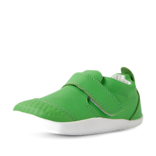 The Bobux Xplorer XP Go Retro Green First Walker Crawler is a green toddler walking shoe with a Velcro strap and a white sole, photographed against a white background. Designed as one of the best first walker shoes, it features flexible leather for comfort and ease during those early steps., 9420074808981, 9420074808998, 9420074809001