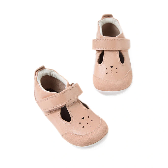 The Bobux XP Explorer Rue First Walker Sandal Camo Rose Pink is a pair of adorable light pink toddler sandals with flexible soles, Velcro straps, and playful animal face details with cut-out heart shapes and stitched noses, displayed on a white background. Perfect for little ones taking their first steps, these baby walking shoes combine comfort and style.