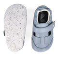 The Bobux XP Explorer Beau First Walker Sandal 502303 features light blue toddler shoes with white, speckled flexible soles; one shoe is shown from the top, the other from the bottom showing tread and size label—ideal for first steps., 9420075784628, 9420075784994, 9420075783652, 9420075783188