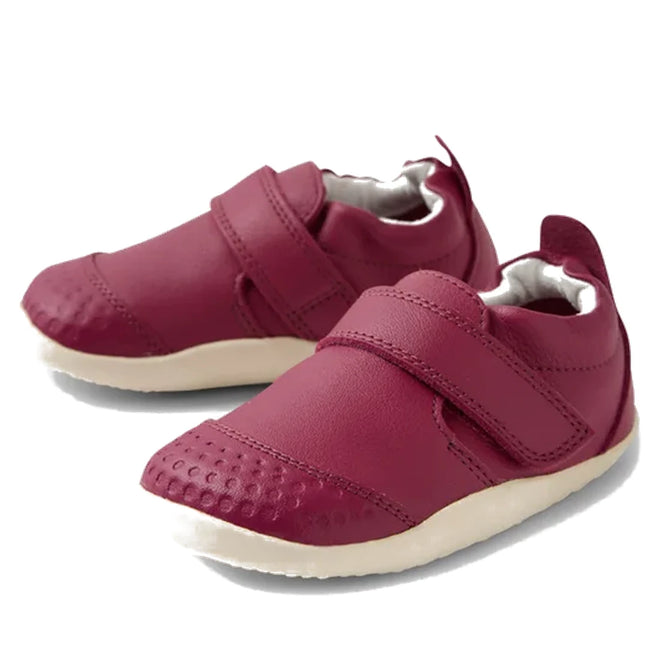 A pair of Bobux XP Xplorer First Walking Shoes Go in Beaujolais Purple, featuring white soles and Velcro straps, displayed on a white background.