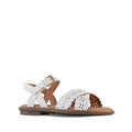 The Clarks Girls Hallie White Sandals (E width) feature scalloped edges, cutout patterns, a flat brown sole, and an adjustable ankle strap with gold buckle fastening.