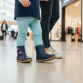 Child wearing navy boots with pink accents in a shopping mall setting, 36295, 9336078981011, 9336078981035, 9336078981059, 9336078981073, 9336078981097, 9336078981110, 9336078981134