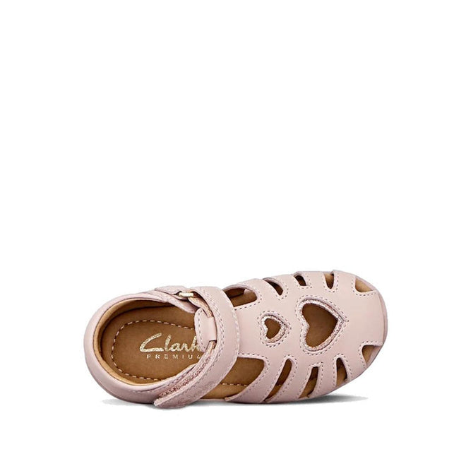 The Clarks Melody Rose Pink Lilac Toddlers Leather Closed Toe Sandal features a pink design with heart-shaped front cutout, multiple side cutouts, Velcro strap, and Clarks Premium branding—ideal for comfortable kids’ wear., 9336078228765, 9336078228802, 9336078228840, 9336078228888, 9336078228925, 9336078228963, 9336078229007, 9336078229045