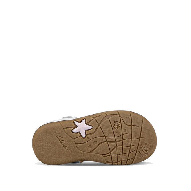 The image shows the sole of the Clarks Saskia White Toddlers Leather Sandal (E width). The brown rubber sole features a pink star, wave-like patterns, a small fish design, and the Clarks logo. These sandals have an adjustable strap for comfort and fit., 40555, 40556, 9336078240163, 9336078240200, 9336078240248, 40560, 40561, 9336078240422, 9336078240460, 9336078240507