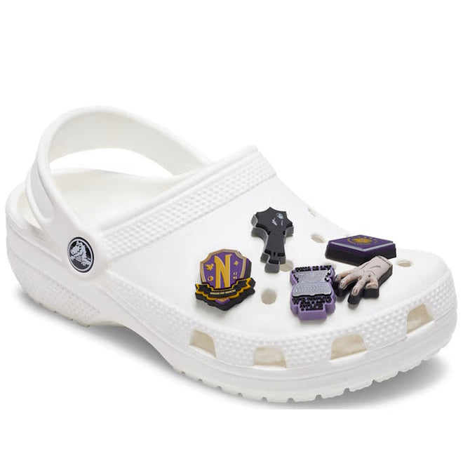 A white Crocs shoe featuring a heel strap and perforated upper is adorned with the Crocs Jibbitz 5 Pack - Adams Family, colorful enamel charms with various themed designs., 196265727964