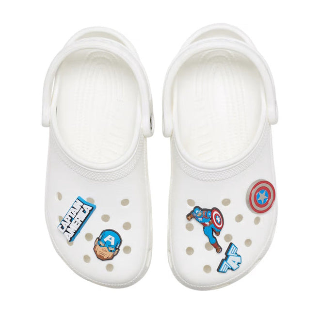 A pair of white slip-on clogs with Captain America-themed Crocs Jibbitz 5 Pack charms—featuring his shield, face, letter A, and comic-style designs—decorating the footwear’s perforated uppers., 196265702695