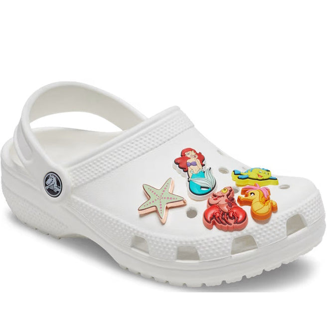 A white Crocs clog decorated with the Crocs Jibbitz 5 Pack - Princess Ariel shoe charms, featuring Princess Ariel, a green starfish, Sebastian the crab, and Flounder; the Crocs logo shows near the heel strap., 41286