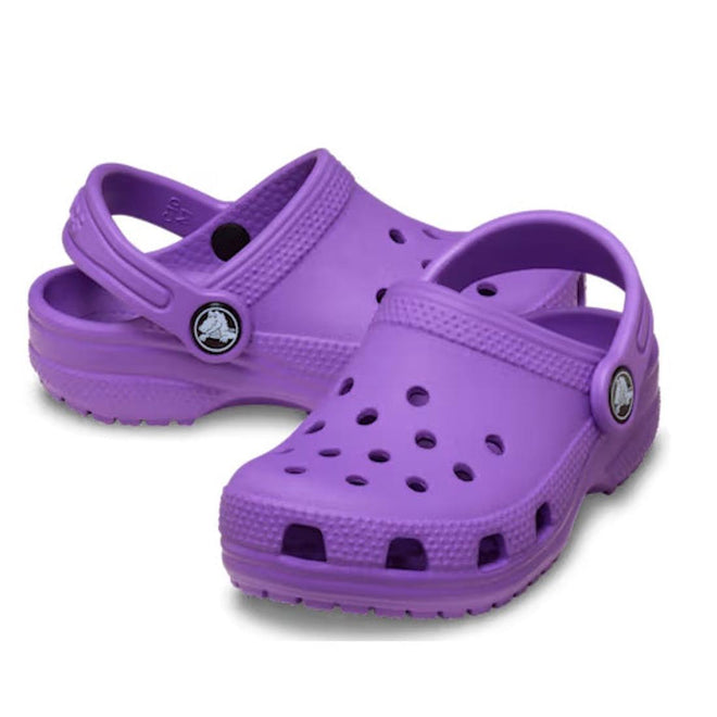 The Crocs Kids - Classic Clog Purple (Junior Youths Sizes) features ventilation holes and adjustable heel straps, is water-friendly, and is shown on a white background.