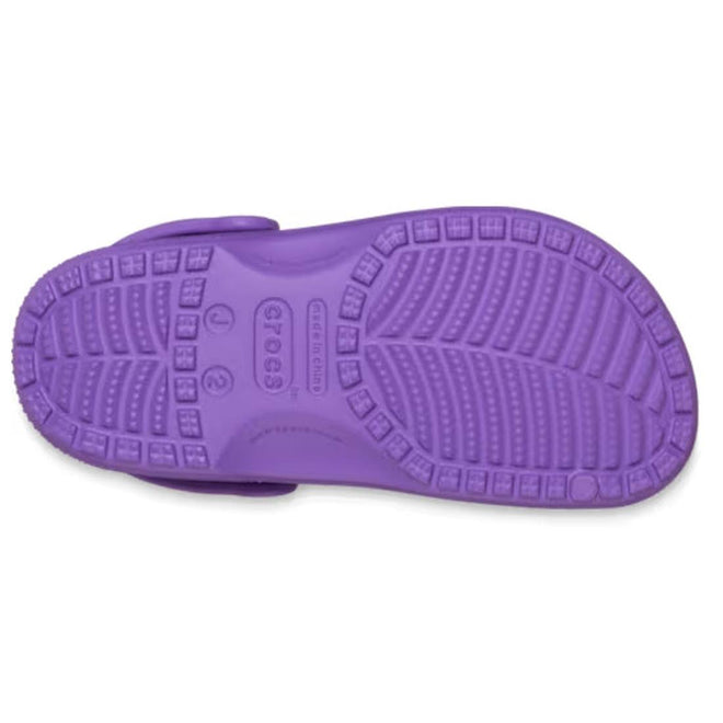 The image shows the sole of the Crocs Kids - Classic Clog Purple - Junior Youths Sizes, with textured treads and the Crocs logo in the center., 198445337628, 198445337635, 198445337642, 198445337659, 198445337666, 198445337673, 198445337680, 49895, 49896