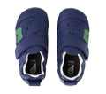 A pair of Bobux XP Explorer Little Sprouts Blueberry Dash First Walker Blue toddler shoes, featuring smiling faces and green leaf designs, viewed from above. These blue leather baby shoes have hook-and-loop straps, flexible soles for comfortable movement, and white interiors., 9420074869388, 9420074869395, 9420074869401