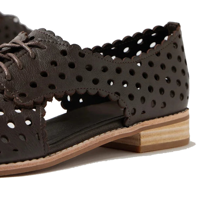 Close-up of the Django & Juliette Adalina Leather Women’s Cut Out Brogues Summer Shoes in Chocolate Brown—a dark brown leather lace-up shoe with scalloped edges, round perforations, and a low stacked wooden heel. Expertly crafted from breathable leather, this style features an open side design for extra comfort and flair.