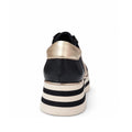 A rear view of the Django & Juliette Eminta Platform Shoe Sheer Leather Black Milk Lace Up, showing black and gold details, sheer side panels, and a thick white and black chunky platform sole against a white background.