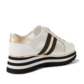 The Django & Juliette Eminta Platform Shoe is a white women’s sneaker featuring sheer leather side panels, black and gold stripes, a gold heel accent, and a thick black-and-white striped platform sole.
