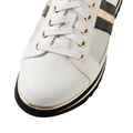 A close-up of the Django & Juliette Eminta Platform Shoe features sheer leather panels, gold eyelets, black and gold side stripes, white laces, and a black-and-white sole.