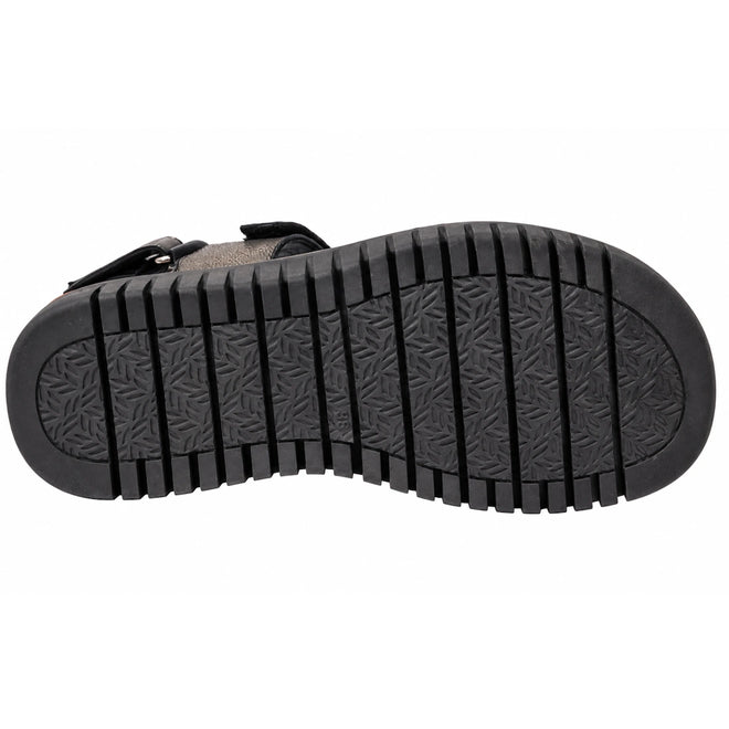 The image shows the black rubber sole of the Django & Juliette Inbar Womens Black Sandal w/Back Strap, featuring deep horizontal grooves and a subtle triangular patterned texture in the center.