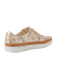 Introducing the Django & Juliette Torayne Womens Ombre Beige Sneakers—an eye-catching women’s sneaker featuring a chic gold and beige snakeskin pattern, cork trim above a chunky white sole, and gleaming gold laces. Shown at an angle that highlights both its side and back design, this standout pair redefines casual footwear with bold style.