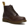 The right foot showing the front and side Brown leather Dr Martens 101 6 eye boot with yellow stitching and brass looking eyelets on a white background.,
