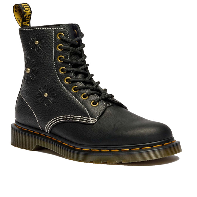 The Dr Martens Women's 1460 Pascal Flower Black Grizzly Leather Boot features yellow stitching, embossed floral details, white stitching accents, a back loop, and a thick translucent brown sole.