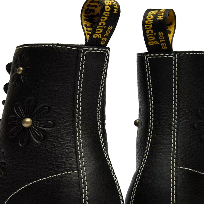 Close-up of the back of two Dr Martens Women's 1460 Pascal Flower Black Grizzly Leather Boots with white stitching, floral embossing, and yellow pull tabs reading "WITH BOUNCING SOLES" in black and yellow text., 52216, 190665781137, 190665781144, 190665781151, 190665781175, 190665781182, 52222