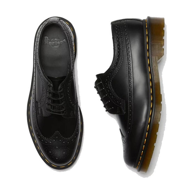 a shot of the right foot top down showing the brogue detailing over yhe toe and the side view of the fet foot shwoing the brouge detailing down the side of a Dr Martens leather 5 eye 3989 shoe.,
883985987371,
883985987388,
883985987395,
883985987425,