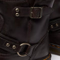 Close-up of Dr Martens Anistone Harness Bex Crazy Dark Brown Horse Biker Boots with a slightly glossy, textured leather, metal buckles, rivets, circular ring detail, and orange stitching accenting the sole., 49399, 190665745689, 190665745696, 190665745719, 49407, 49409, 49411, 49412