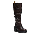 The Dr Martens Womens Kasey Hi Knee High Pull On Boot features dark brown Kinsley leather, a chunky sole and heel, visible stitching, yellow pull tab on the shaft, and a slightly slouched look.