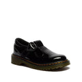 The Dr. Martens kids Polley II Heart T Bar Junior in Black Patent is a Mary Jane-style shoe with a chunky sole, decorative heart buckle strap, and the classic yellow stitching.