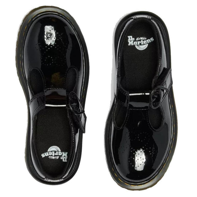 Top view of Dr Martens kids Polley II Heart T Bar Junior Black Patent shoes with shiny black patent leather, thick yellow-stitched soles, and buckle straps, placed side by side on a white background., 50432, 50433, 190665786743, 190665786750, 190665786651, 190665786675, 190665786699