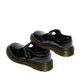 A pair of Dr Martens kids Polley II Heart T Bar Junior Black Patent shoes with chunky translucent soles, yellow stitching, and a buckle strap—perfect school shoes—photographed against a white background., 50432, 50433, 190665786743, 190665786750, 190665786651, 190665786675, 190665786699