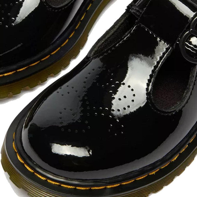 Close-up of Dr Martens kids Polley II Heart T Bar Junior Black Patent shoes with yellow stitching, thick soles, T-bar straps, and heart perforations—perfect as stylish school shoes., 50432, 50433, 190665786743, 190665786750, 190665786651, 190665786675, 190665786699