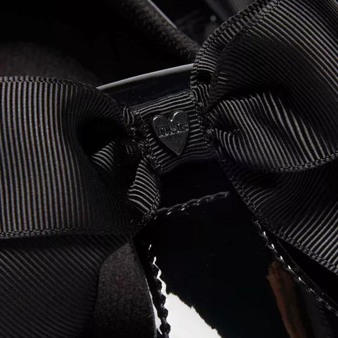 Close-up of a bow on the Dr Martens Polley T Bar black shoe with a large bow and a visible brand logo.,
190665761818,
190665761832,
190665761856,
190665761863,
190665761764,
190665761788,
190665761801,
