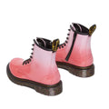 The Dr Martens Kids 1460 Junior Pink Glitter Ombre Gradient boots feature shiny pink ombré glitter, black laces, side zippers, thick speckled soles, and black and yellow pull-tabs on the back.