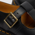 Close-up of a black Dr Martens polley brass looking buckle and t-bar strap over the top of the foot. Also part shoes the tan lining.
883985498242,
883985498259,
883985498266,
883985498273,
883985498280,
883985498297,
883985498303,
883985498310,