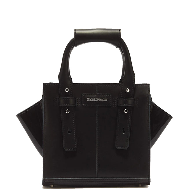 The Dr Martens Small Keiv Leather Tote Bag Black is a structured small tote crafted from black Kiev leather, featuring two top handles with decorative patent Lamper straps and a small rectangular logo patch on the front, shown against a white background.