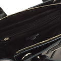 Close-up of the Dr Martens Small Keiv Leather Tote Bag in black, crafted from premium Keiv leather. The bag features a zippered inner pocket and is finished with sleek patent Lamper straps. The zipper and fabric details are clearly visible inside the bag.